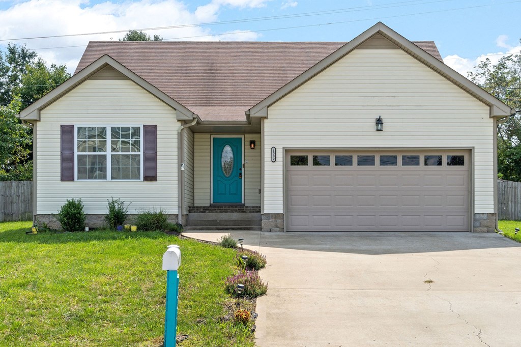 a white house with a blue door and a driveway