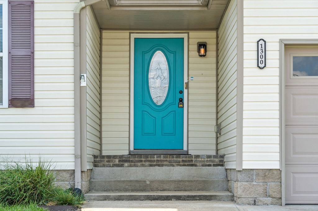 the front door of a house with a blue door and stairs