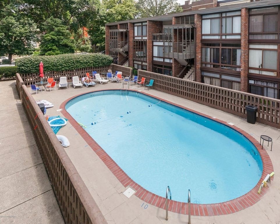 A large outdoor swimming pool surrounded by a brick wall.