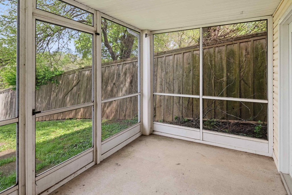 A sunroom with a view of a backyard.