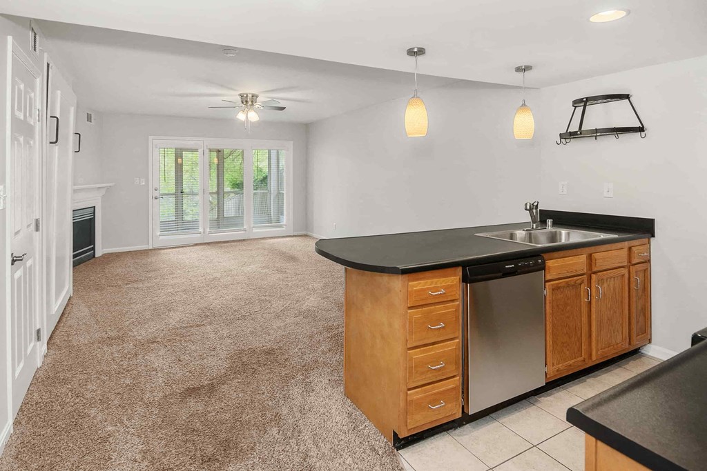 A kitchen with a black countertop and wooden cabinets.