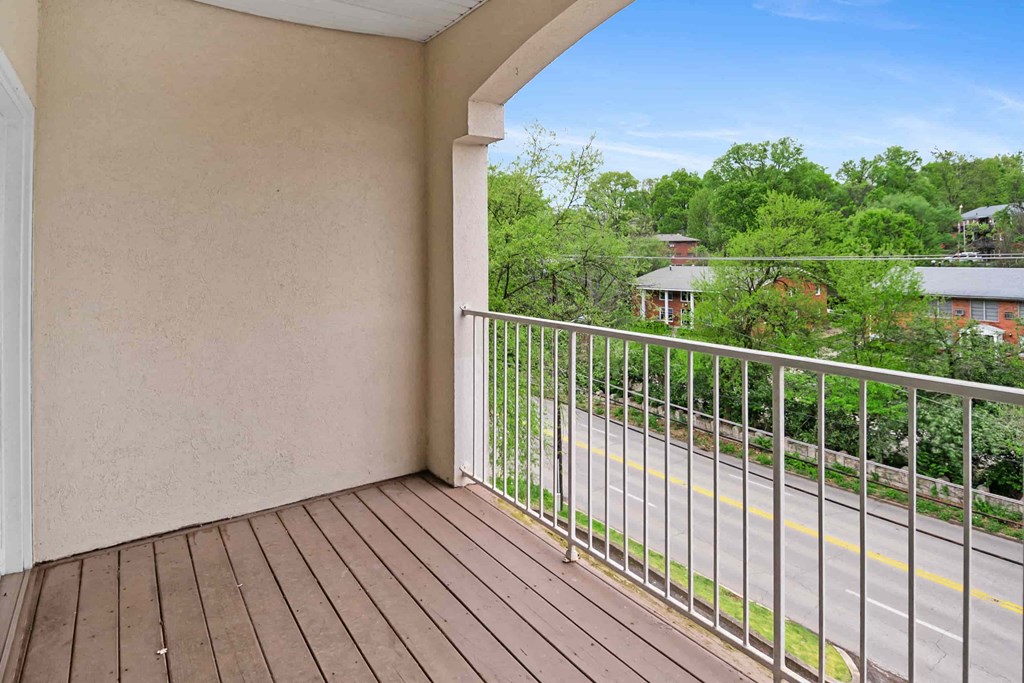 A balcony with a metal railing overlooking a road.