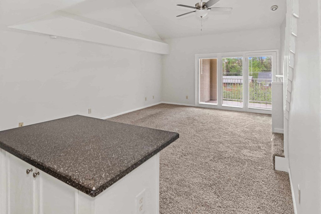 A room with a granite countertop and a ceiling fan.