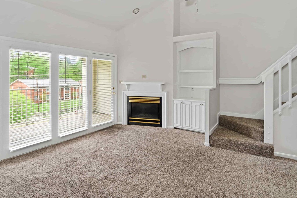 A room with a fireplace and a staircase.