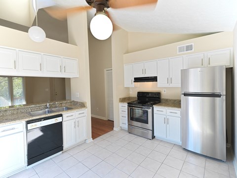 A kitchen with white cabinets and appliances.