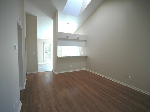 A room with a skylight and wooden floors.