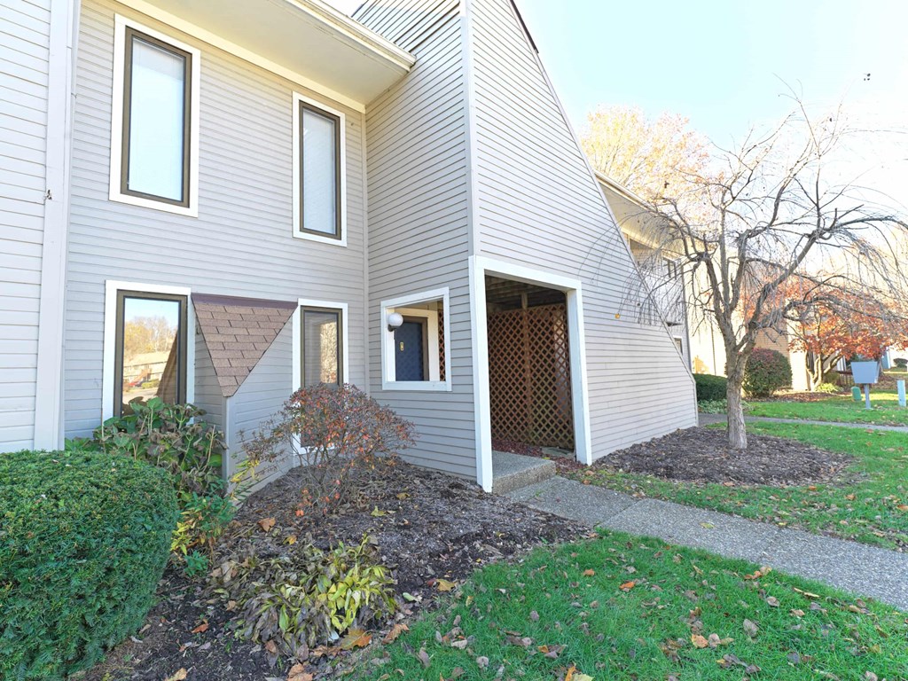 A house with a grey siding and a brown roof.