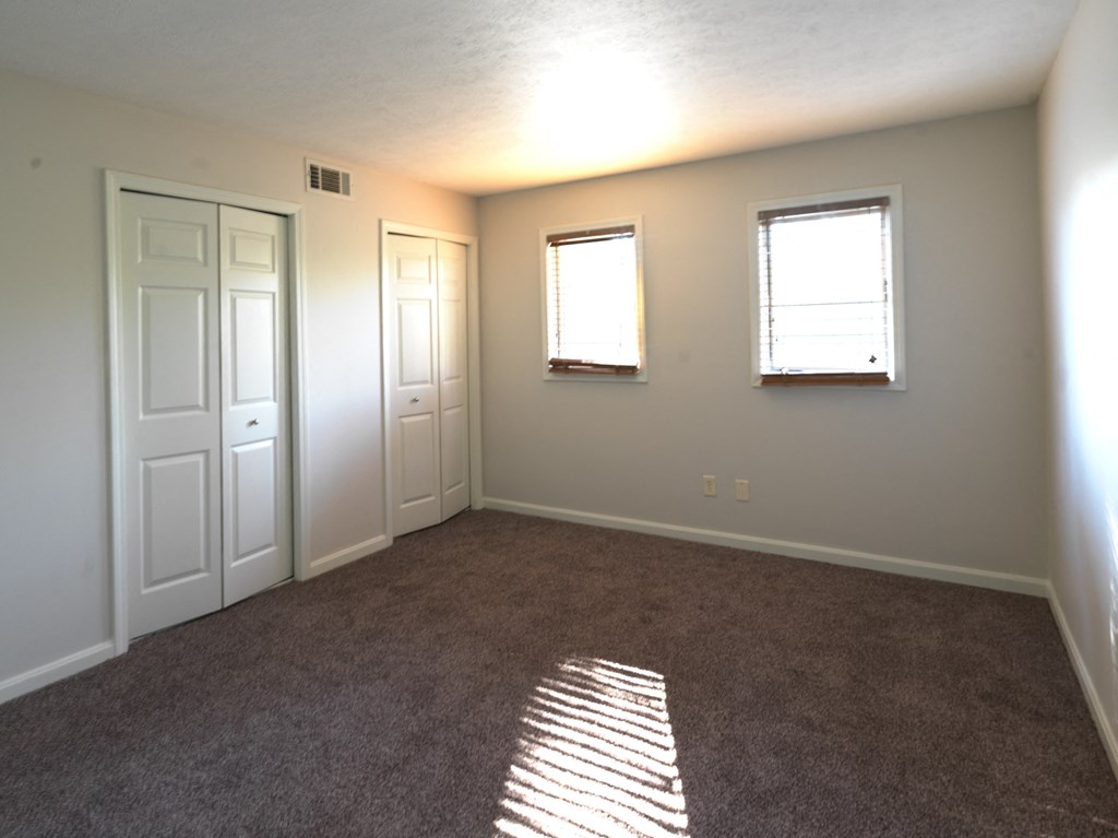 A room with two doors and two windows.