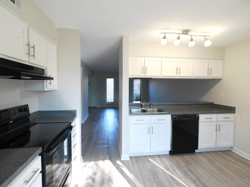 A kitchen with black appliances and white cabinets.
