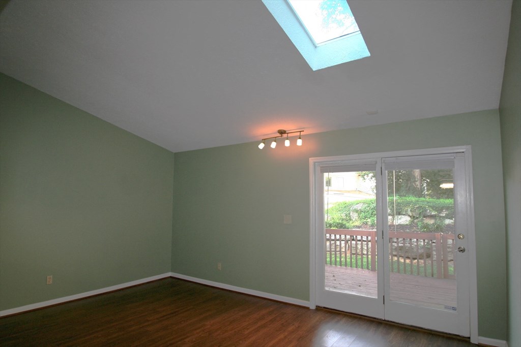 A room with a skylight and a door leading outside.