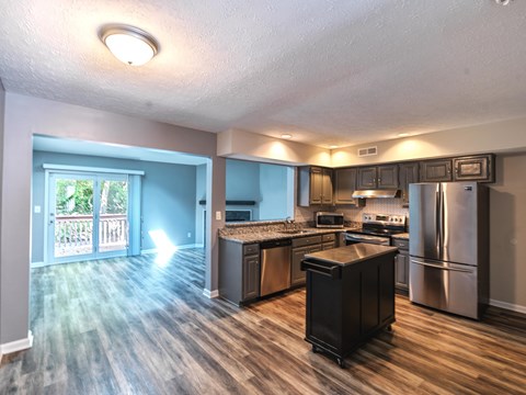 A kitchen with a refrigerator, stove, and oven.