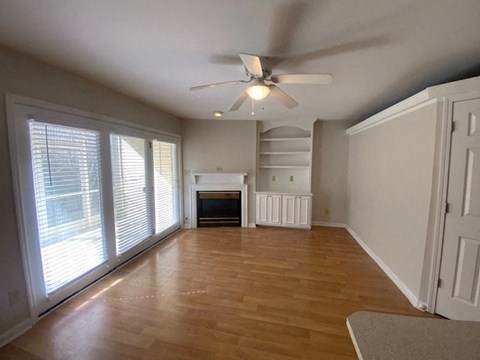 A room with a fireplace and a ceiling fan.