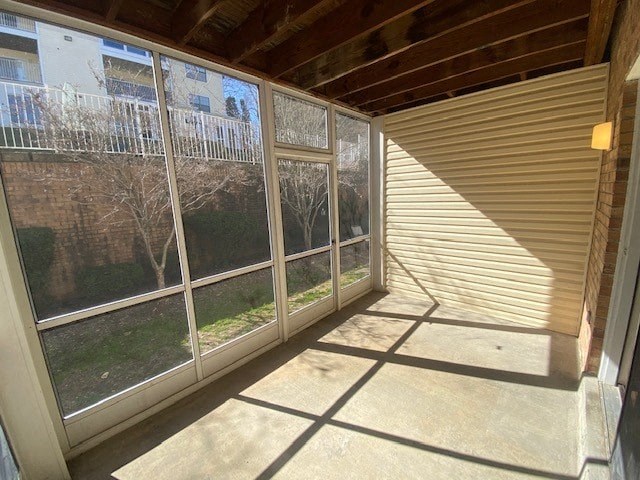 A sunny day with a view of a tree and a building through a sliding glass door.