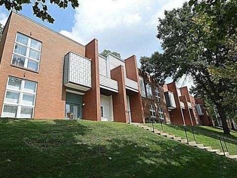 A red brick building with a green lawn in front.