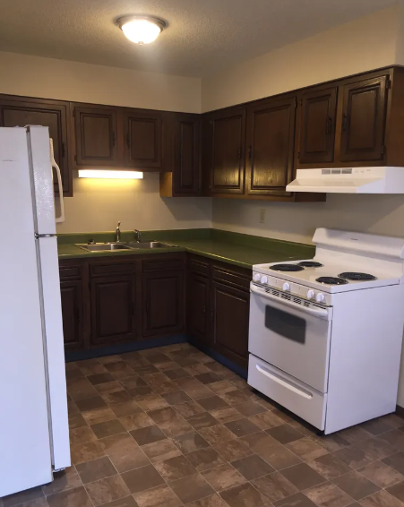 a kitchen with a stove refrigerator and a sink
