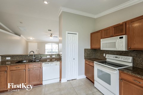 a kitchen with white appliances and wooden cabinets