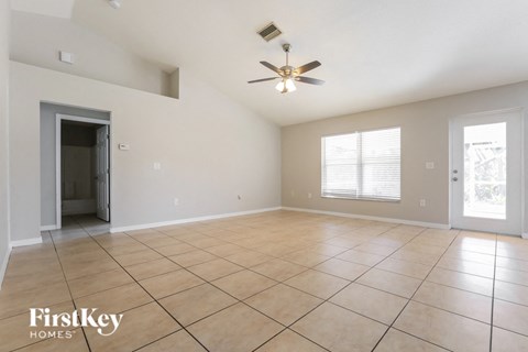A spacious room with a ceiling fan and tile flooring.