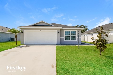 a white house with a driveway and a lawn