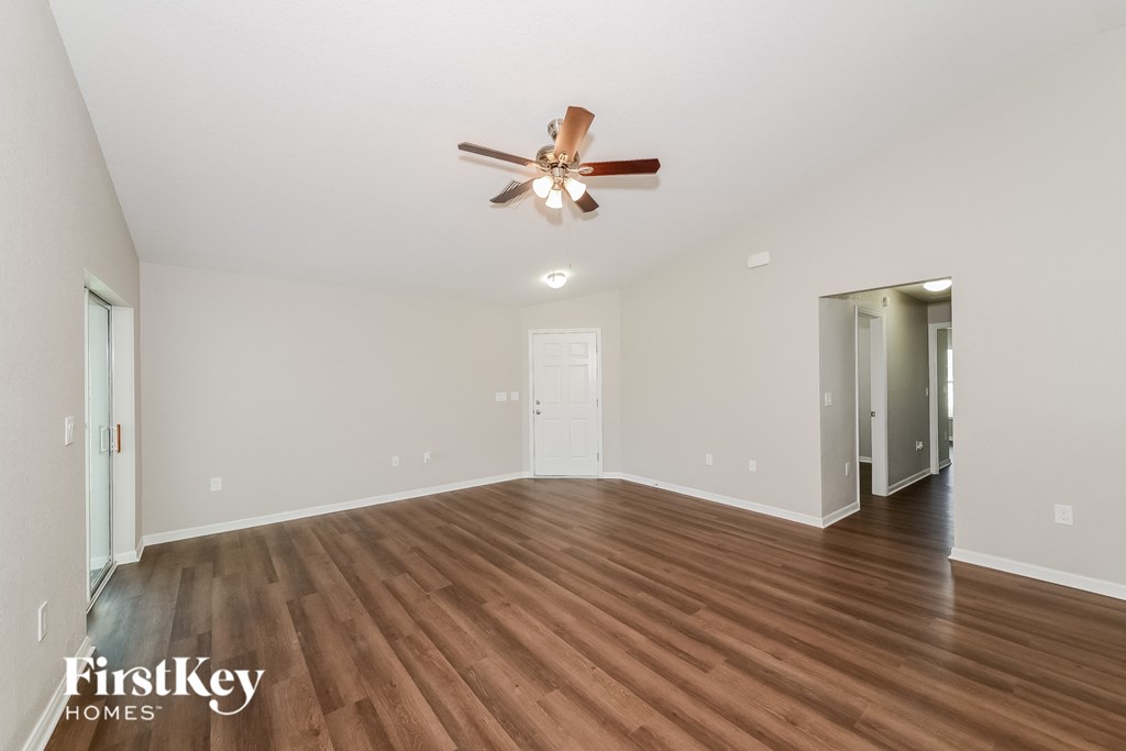 a living room with hardwood floors and a ceiling fan