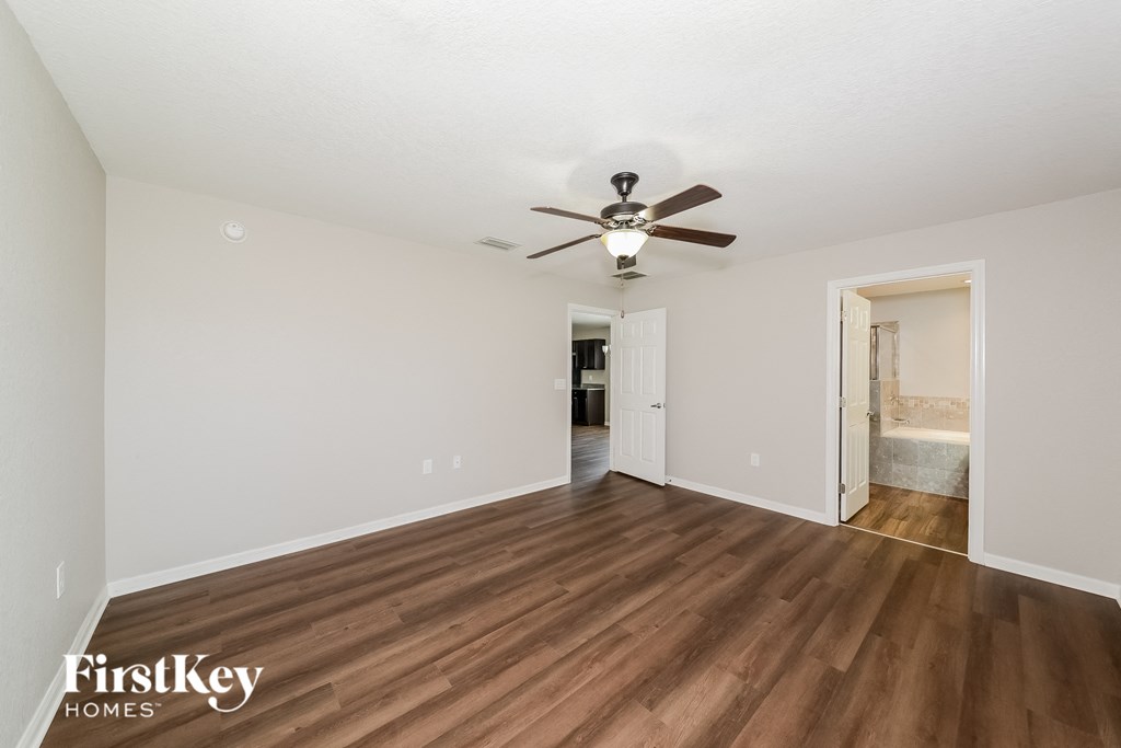 a living room with a ceiling fan and wood flooring