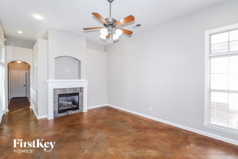 A room with a fireplace and a ceiling fan.