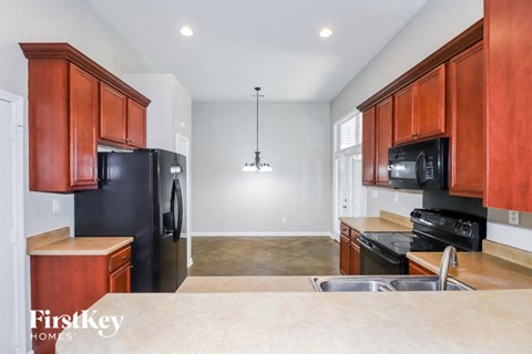 A kitchen with wooden cabinets and black appliances.