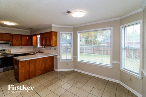 A kitchen with wooden cabinets and a tiled floor.