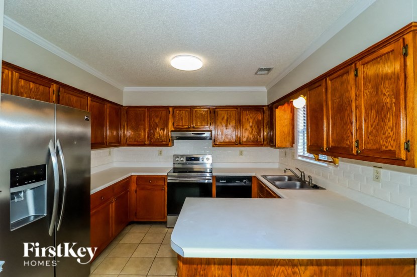 A kitchen with wooden cabinets and a stainless steel refrigerator.