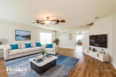 A living room with a white couch, a coffee table, and a painting on the wall.