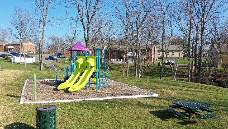 a playground with a slide and a picnic table