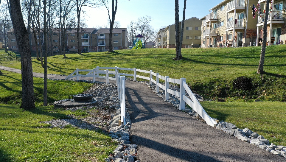 a bridge over a path in a park
