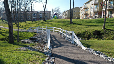 a bridge over a path in a park