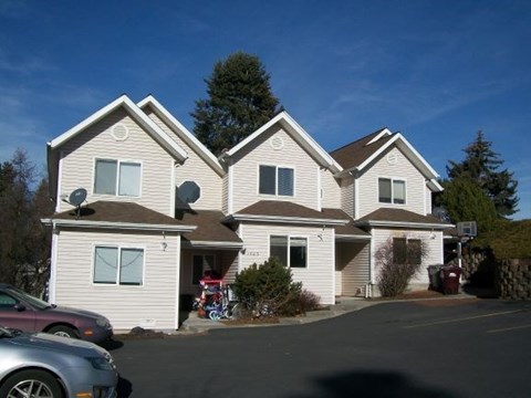 A large house with a car parked in front.