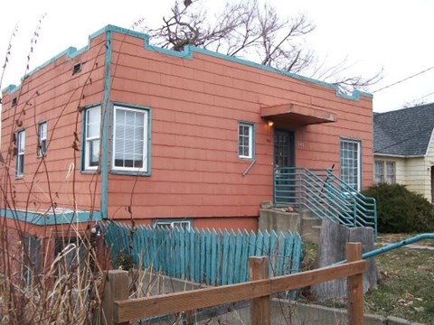 a red house with a fence in front of it
