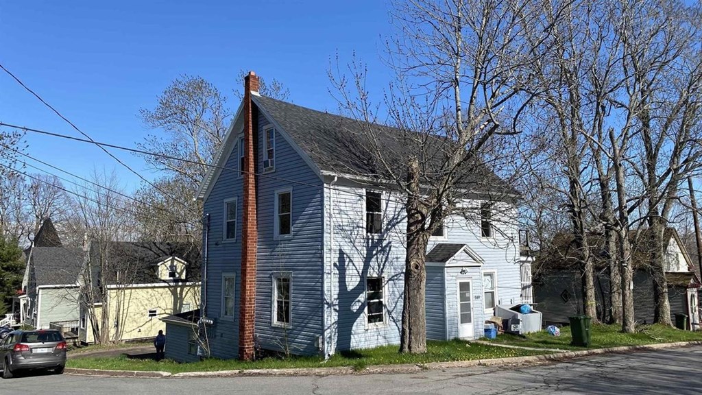a blue and white house with a car parked in front of it