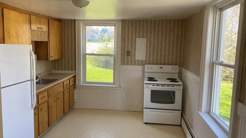 a kitchen with a stove and a refrigerator and a window