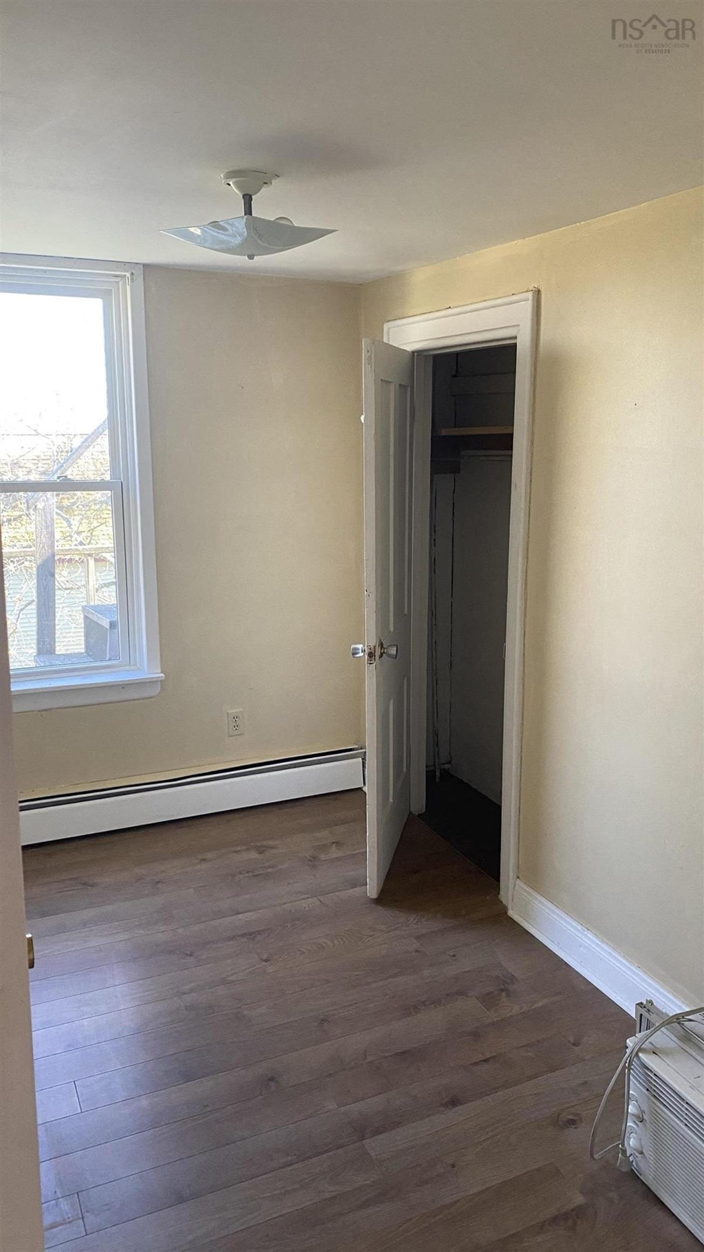an empty room with wooden floors and a ceiling fan