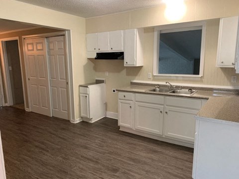 A kitchen with white cabinets and a sink.