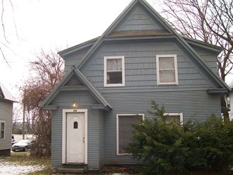 the front of a blue house with a white door