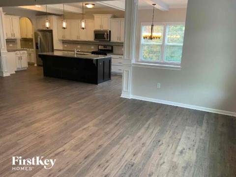 A kitchen with a black countertop and wooden flooring.