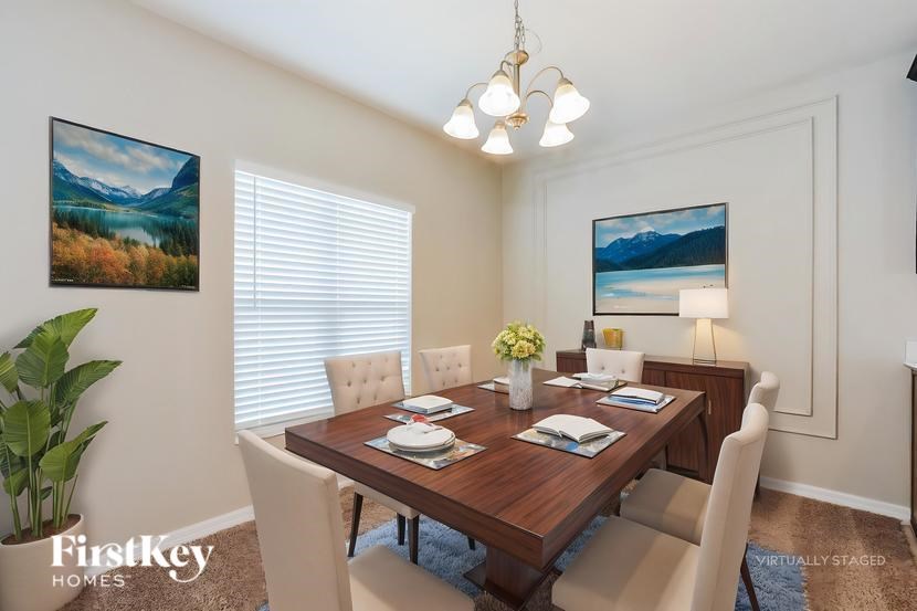 A dining room with a wooden table set for two.