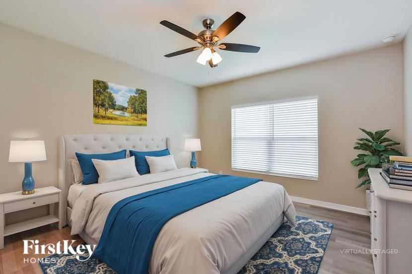 A bedroom with a large bed and a ceiling fan.