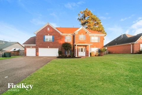 a large brick house with a lawn in front of it