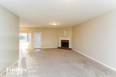 a living room with a fireplace and a carpeted floor