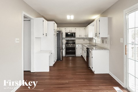 a white kitchen with white cabinets and a wood floor