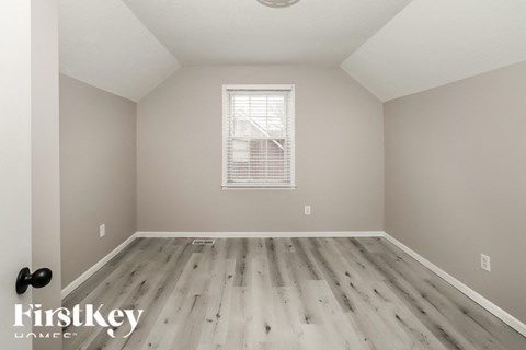 a spacious room with hardwood floors and a window