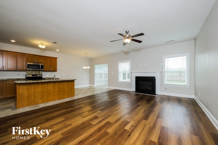 A spacious living room with wooden floors and a fireplace.