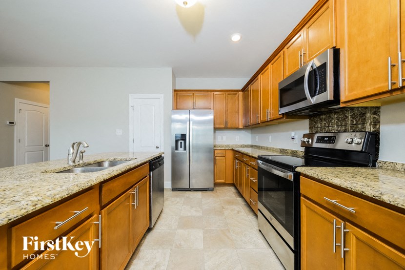 A kitchen with wooden cabinets and a granite countertop.
