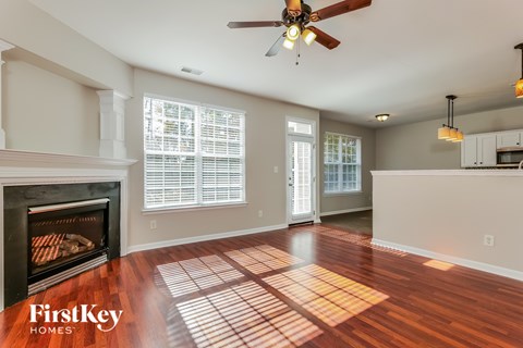 A spacious living room with a fireplace and wooden floors.