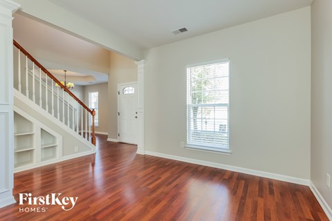 A room with wooden floors and a staircase.